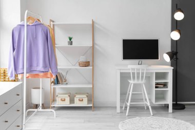 Modern iş yeri, askılık ve kapüşonlu ışıklı oturma odasının içinde.