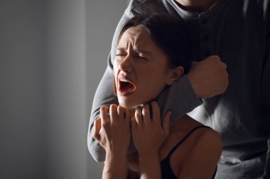 Genç kadını boğazından tutan adam. Şiddet kavramı