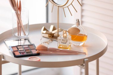 Odada makyaj fırçaları ve parfüm şişeleri var.