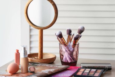 Odada makyaj fırçaları, kozmetik ürünleri ve dergileri olan tutucu