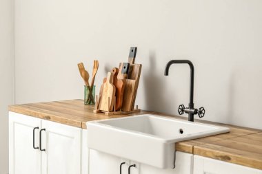 Kesme tahtaları, spatulalar ve ışık duvarının yanındaki tezgahlarda lavabo.