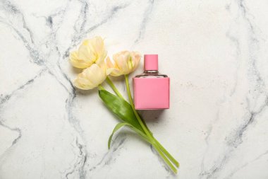 Bir buket güzel lale ve arka planda parfüm şişesi.