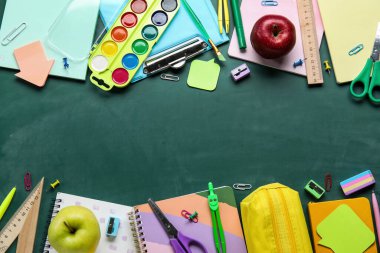 Okul kırtasiyesinden ve yeşil karatahtanın üzerindeki elmadan yapılmış çerçeve