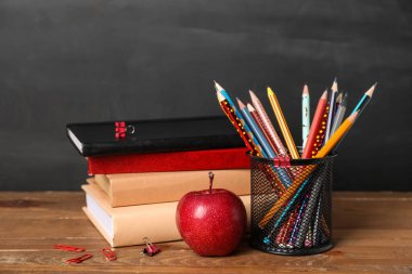 Tahtanın yanındaki masada elmalı okul kâğıdı.