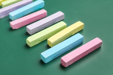 Yeşil tahtada renkli tebeşirler, yakın plan.