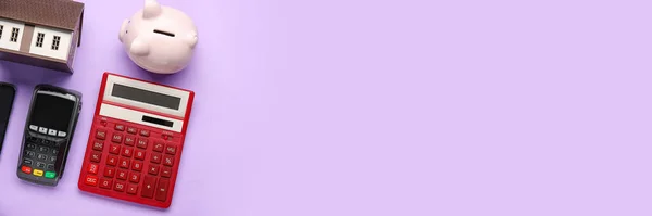 紫丁香背景下房屋 支付终端和储蓄罐模型计算器 有文字空间 — 图库照片