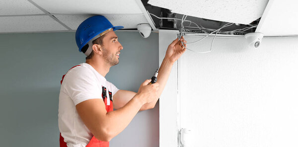 Technician installing smart home security system in room