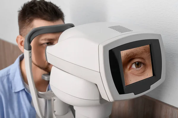 Man checking his eyesight at ophthalmologist's office