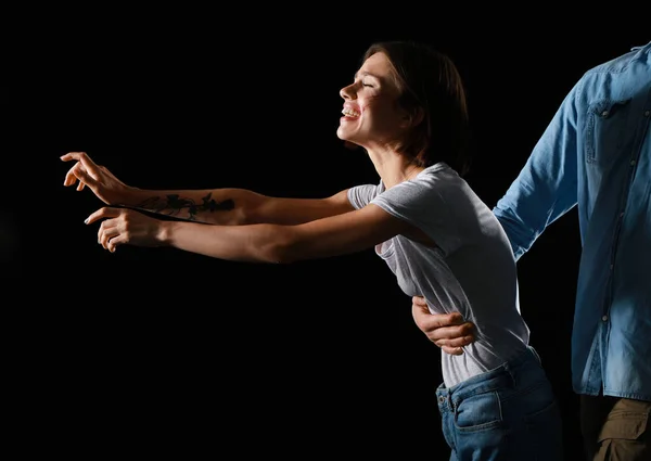 Man beating scared woman on dark background. Violence concept