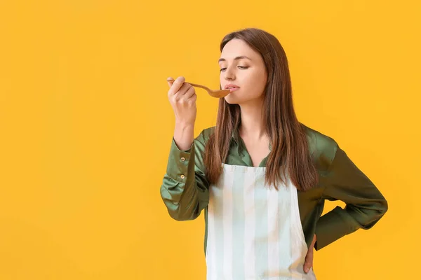 Pretty Young Woman Tasting Food Wooden Spoon Yellow Background — Stock Photo, Image