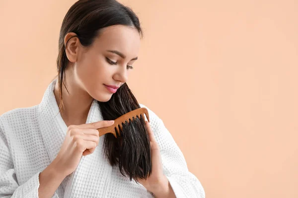 Jovem Escovando Cabelo Com Óleo Coco Fundo Bege — Fotografia de Stock