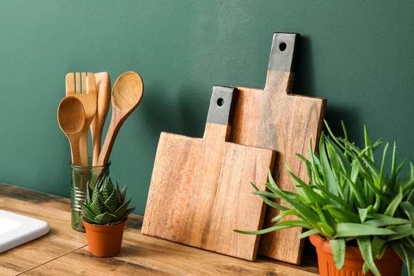 Wooden Cutting Boards Spatulas Houseplants Counter Green Wall — Stock Photo, Image