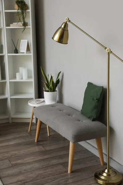 Soft bench with cushion and lamp near light wall