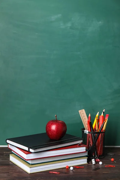 Шкільні Канцелярські Товари Книгами Яблуком Столі Біля Зеленої Дошки — стокове фото