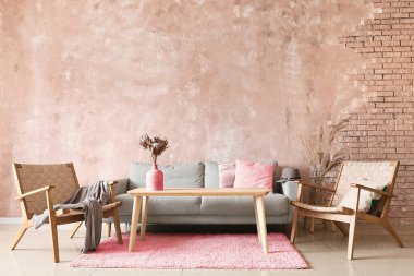 Koltuğu, koltuğu ve renkli duvarın yanındaki ahşap masası olan modern bir oda.