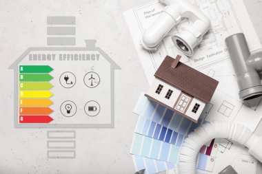 Çizimler, renk örnekleri, tesisat boruları ve ışık arka planında enerji verimliliği derecesi olan yeni ev modeli