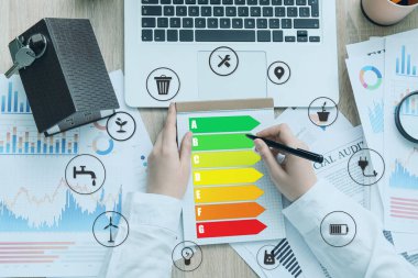 Not defteri, enerji verimliliği derecesi ve dijital simgeleri olan emlakçı, üst görünüm