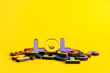 Sarı arka planda harfleri olan LOL kelimesi. Alfabe konsepti