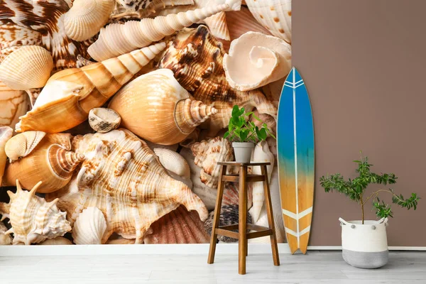 墙边有冲浪板 桌椅和室内盆栽 上面印着海贝壳 — 图库照片
