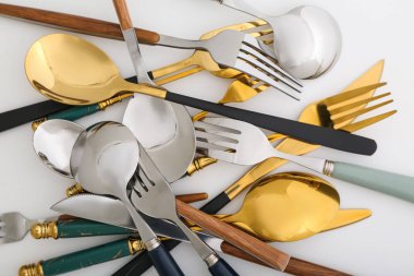 Beyaz arka planda farklı paslanmaz çelik çatal bıçak takımı.