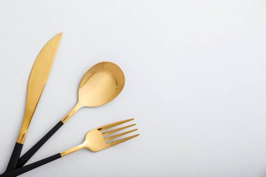 Arka planda siyah saplı paslanmaz çelik çatal bıçak seti, yakın plan.