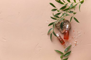 Bej arka planda doğal serum, taş, tuz ve bitki yaprakları.