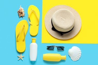 Renkli arka planda güneş kremi ve plaj aksesuarları.