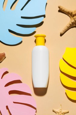 Dekoratif palmiye yapraklı güneş kremi ve bej arka planda deniz yıldızları