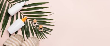 Sandaletler, güneş kremi, açık arkaplanda tropikal yaprak ve küpeler metin için alan