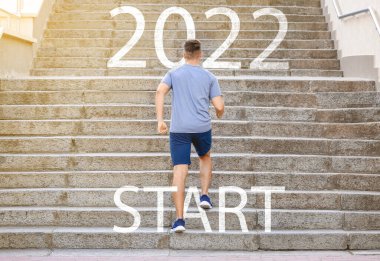 Dışarıda merdivenlerden koşarak çıkan genç bir sporcu. 2022 gol kavramı