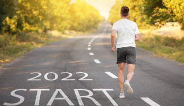 Sportif genç adam yolda koşuyor. 2022 gol kavramı