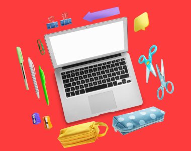 Boş ekran ve kırmızı zemin üzerinde okul malzemeleri olan modern bir dizüstü bilgisayar.