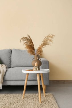 Gri kanepesi ve masası olan oturma odasının içinde.