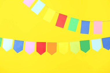 Sarı arka planda Festa Junina için renkli bayraklar