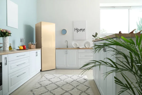 Interior of modern comfortable kitchen with refrigerator