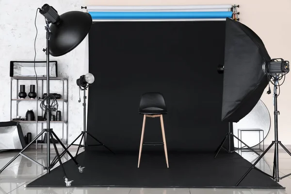 Lighting equipment, chair and cyclorama in modern photo studio