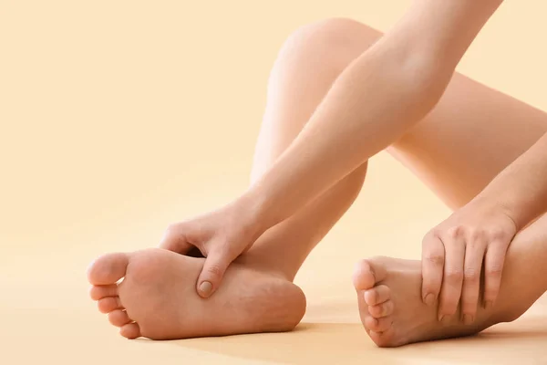 Young Woman Making Foot Massage Beige Background Closeup — Stock Photo, Image