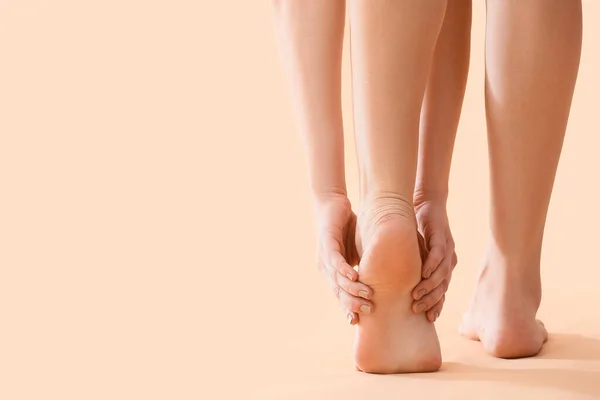 Junge Frau Macht Fußmassage Auf Beigem Hintergrund Nahaufnahme — Stockfoto