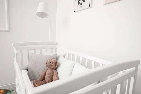Babybedje Met Kussens Teddybeer Bij Lichte Muur — Stockfoto
