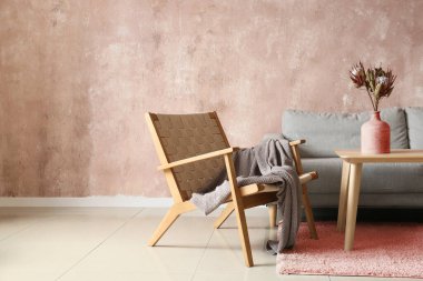 Rahat koltuk, kanepe ve vazo renkli duvarın yanında.