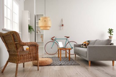 Rahat kanepesi, bisikleti, dizüstü bilgisayarı masa ve koltuğu olan modern oturma odasının içinde.