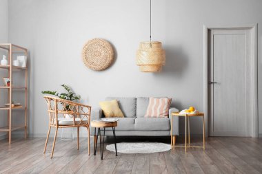 Rahat kanepesi, koltuğu ve lambası olan modern oturma odasının içinde.