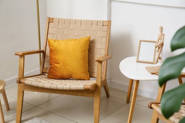 Yastıklı rahat koltuk ve ışık duvarının yanındaki masa.