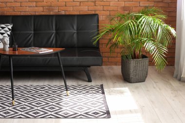 Rahat bir kanepe, çiçekli ve şık bir masa.