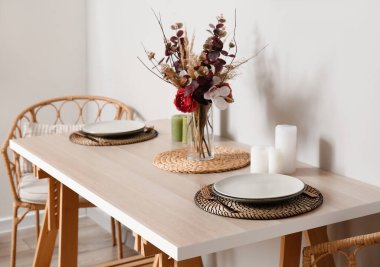 Işık duvarının yanında güzel bir yemek masası.