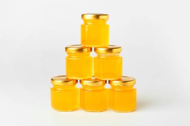 Beyaz arkaplanda bal bulunan kavanozlar