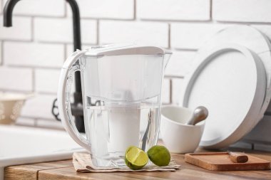 Mutfakta tezgahta su filtresi sürahi ve limon var.