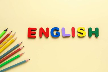Kelime ENGLISH bej arka planda kalemler ile