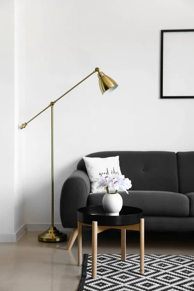 白い壁の近くの快適なソファとモダンなランプ — ストック写真