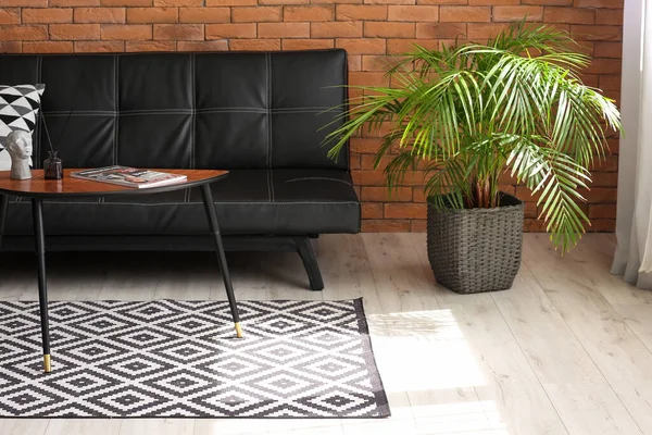 Rahat bir kanepe, çiçekli ve şık bir masa.